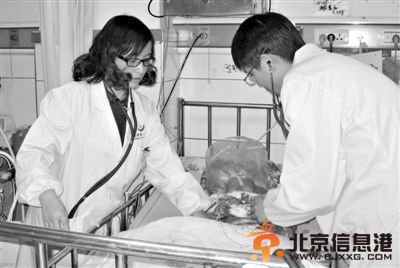 12月13日，常德市第一人民医院医护人员在重症病房为接种乙肝疫苗后出现不良反应的男婴进行检查。新华社发