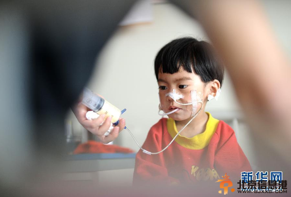 父亲嘴对嘴为患病女儿喂食 坚持500多天(图)