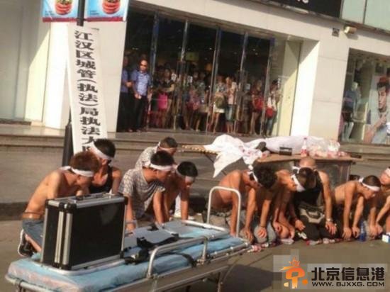 8月3日下午3点，湖北武汉中山大道佳丽广场，十多名赤膊男子披麻戴孝，用门板抬着一具“尸体”在此示威，宣称城管打死人。