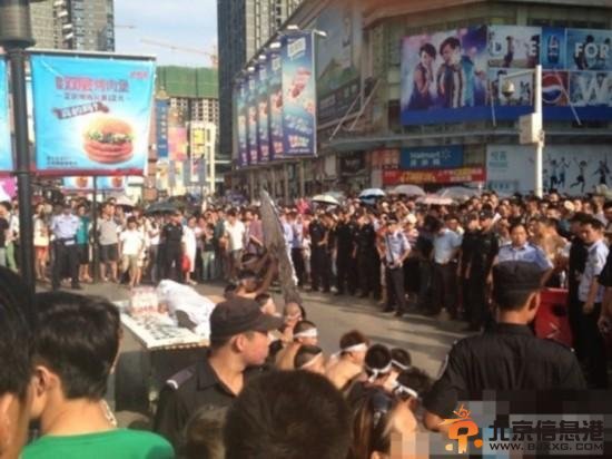 8月3日下午3点，湖北武汉中山大道佳丽广场，十多名赤膊男子披麻戴孝，用门板抬着一具“尸体”在此示威，宣称城管打死人。