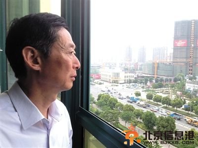 5月21日，蚌埠市民政局内，于英生眼望窗外的高楼大厦。获释9个多月，他还在试着融入一座全新的城市。记者拍完照，他看着照片里的自己，“唉，真的老了。”新京报记者 贾鹏 摄