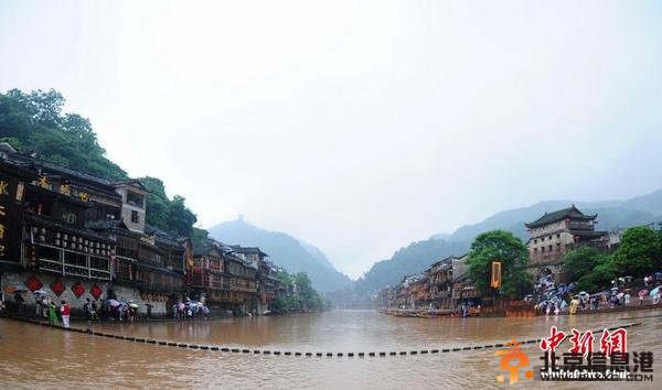 暴雨致凤凰古城内涝 游客洪水中留影