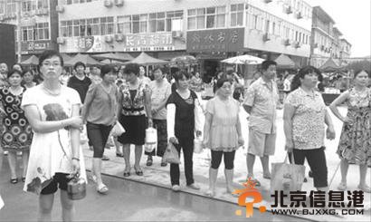 陪读家长们提着饭菜等待自己的孩子出来