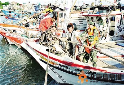 7月22日，边防官兵在福州连江县黄岐中心渔港帮助台胞加固渔船。 新华社记者 张国俊摄