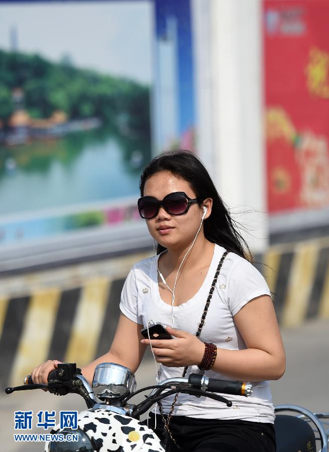 广西南宁气温达到30摄氏度 市民身穿夏装出行