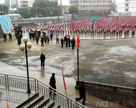 领导打伞学生冒雨做操 为迎接领导视察校方曾称下狗屎也要做操
