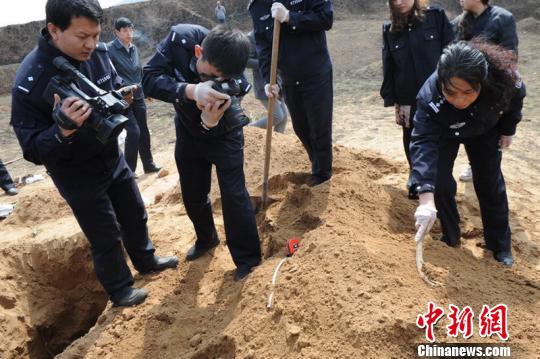 山西忻州警方破获一起特大持枪入室抢劫强奸杀人案。两名受害者被犯罪团伙活埋于墓穴死亡，其中一名同伙因分赃不均被枪杀，目前其他犯罪嫌疑人已悉数落网。图为警方在挖开墓地找到被绑架夫妇的尸体。　警方供图　摄