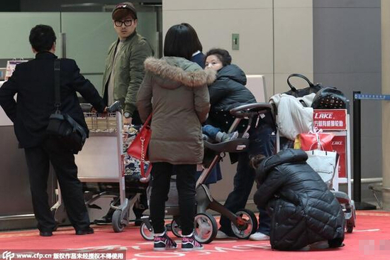 何洁携子现身机场 面容憔悴蹲地休息